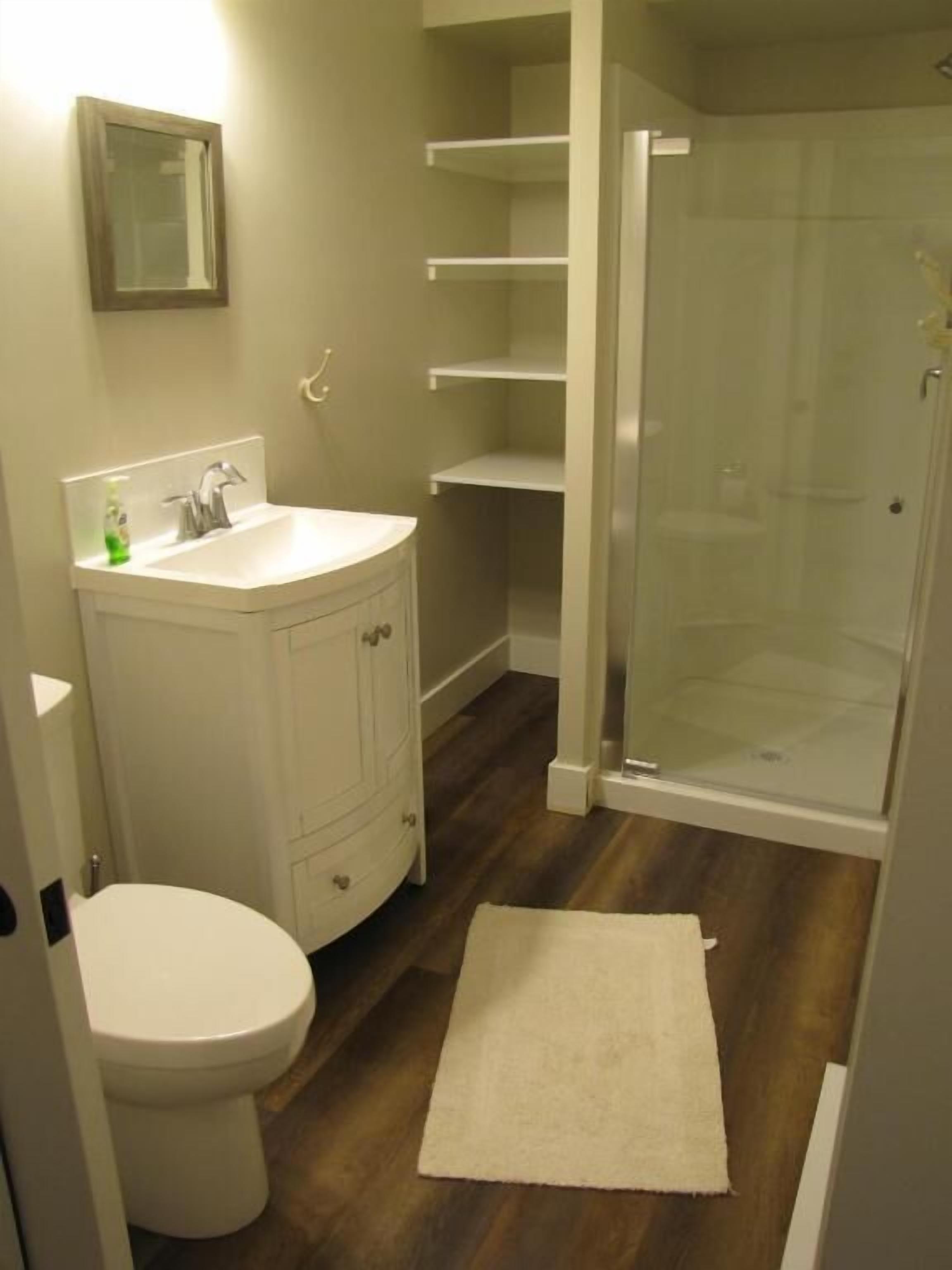 A bathroom with a toilet, sink, and shower.