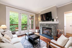 A living room with a fireplace, a sofa, a coffee table, and a television.