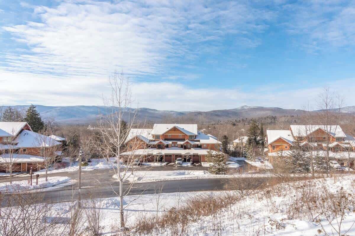 Zona residencial con varias casas, cielo despejado y paisaje nevado.
