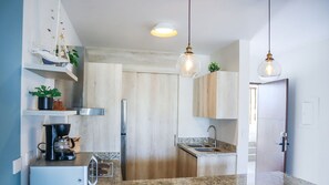 Refrigerador, microondas, licuadora y isla de cocina