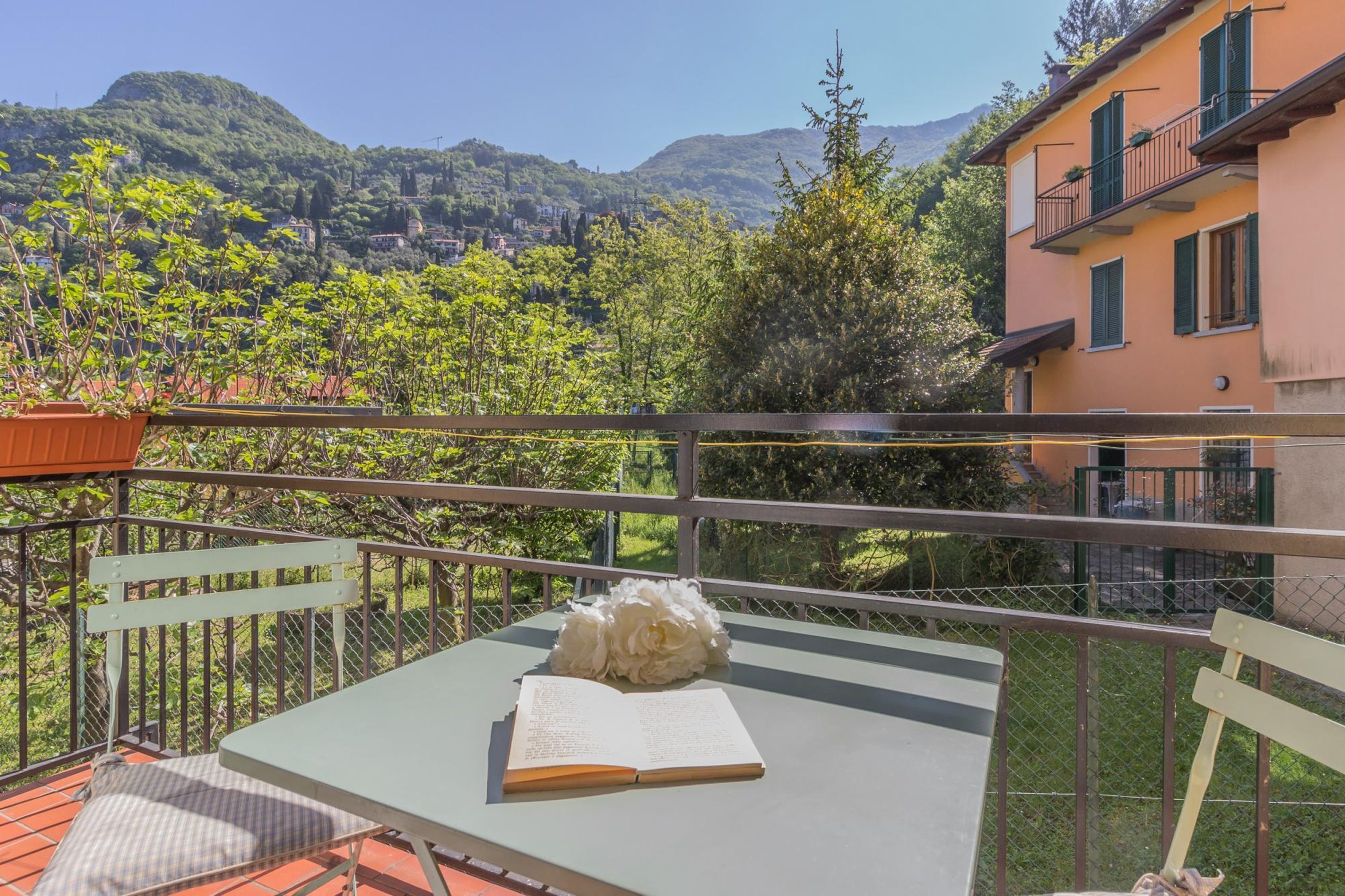 Ein Balkon mit Tisch, Stuhl und Buch.