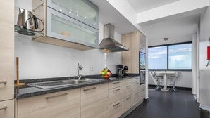 Eine moderne Küche mit Granitabdeckung, Edelstahlgeräten und Holzausstattung.
