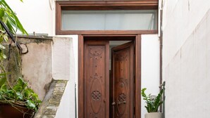 A set of stone steps leading to a wooden door with a glass panel above it. - Meravigghia Apartment by Wonderful Italy (Cefalù)