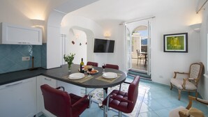 Una cucina moderna con zona pranzo, una TV a muro e vista sull'esterno.