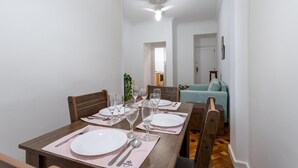 A dining area with a wooden table set for four, including plates, cutlery, and glasses. - 5 Minutes From Leblon Beach Ap102 (Rio de Janeiro)