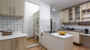 A modern kitchen with white cabinets, a central island, and a tiled backsplash. - 5 Minutes From Leblon Beach Ap102 (Rio de Janeiro)