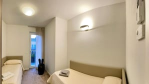 Ett hotellrum med två separata sängar, ett litet bord och en stol.