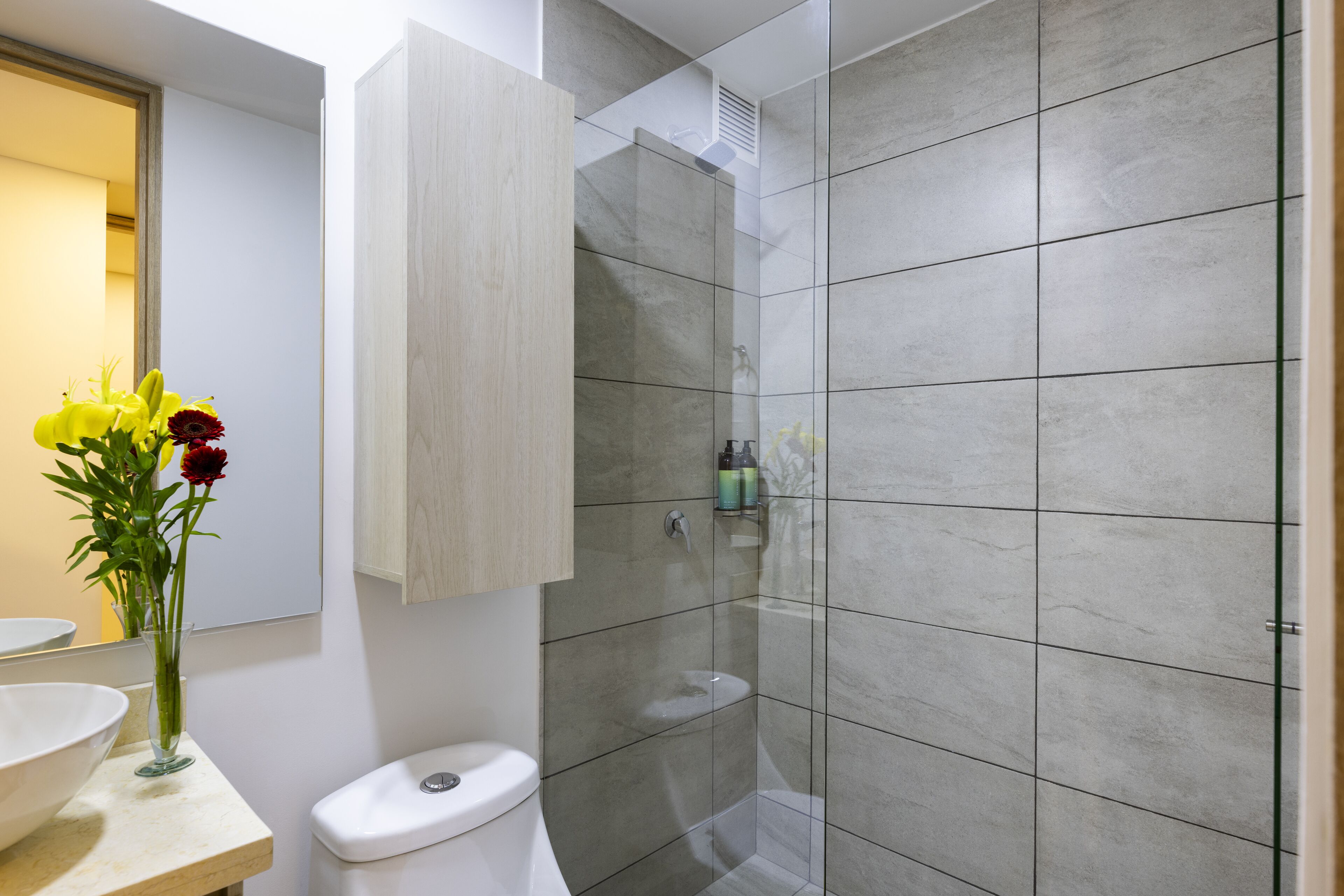 Et moderne badeværelse med toilet, vask og brusebad.