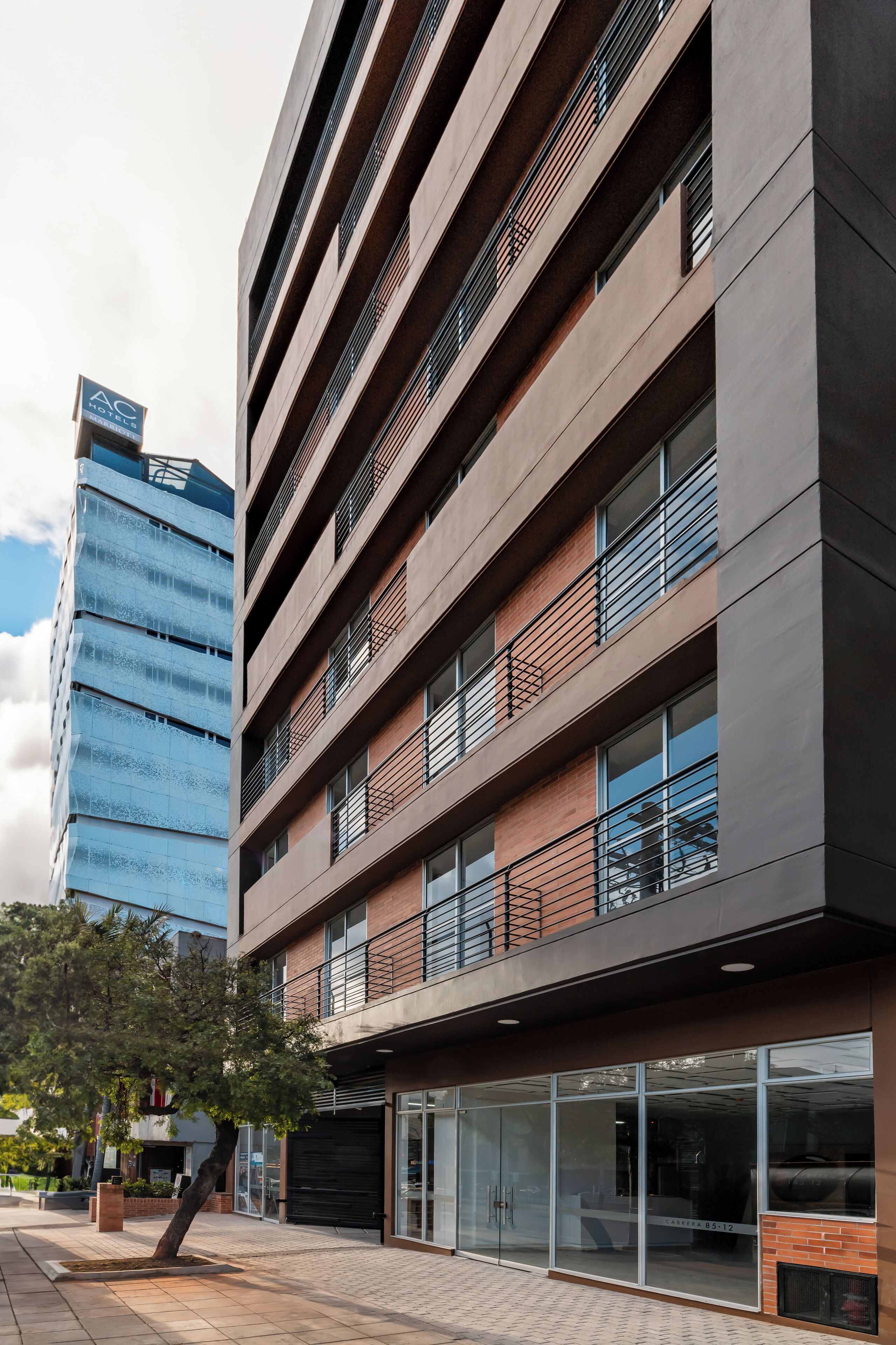 Un bâtiment moderne à plusieurs étages, doté de grandes fenêtres et d’une façade en briques.