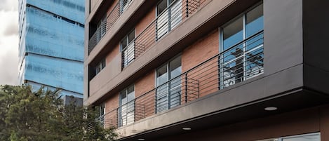 Un bâtiment moderne à plusieurs étages, doté de grandes fenêtres et d’une façade en briques.