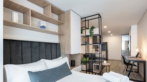 A modern hotel room with a bed, a desk, and a shelving unit with plants. -  Cabrera 85-12 by Jalo (Bogotá)