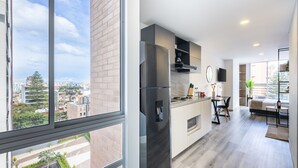 A modern apartment with a kitchen, dining area, and a large window overlooking a cityscape. -  Cabrera 85-12 by Jalo (Bogotá)
