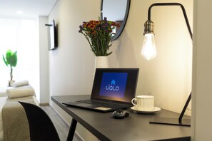 Stay in a stylishly designed room with a desk, vase with flowers, and a unique light fixture.