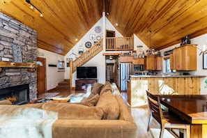 Cozy living area with a stone fireplace, comfortable sofa, and dining table.