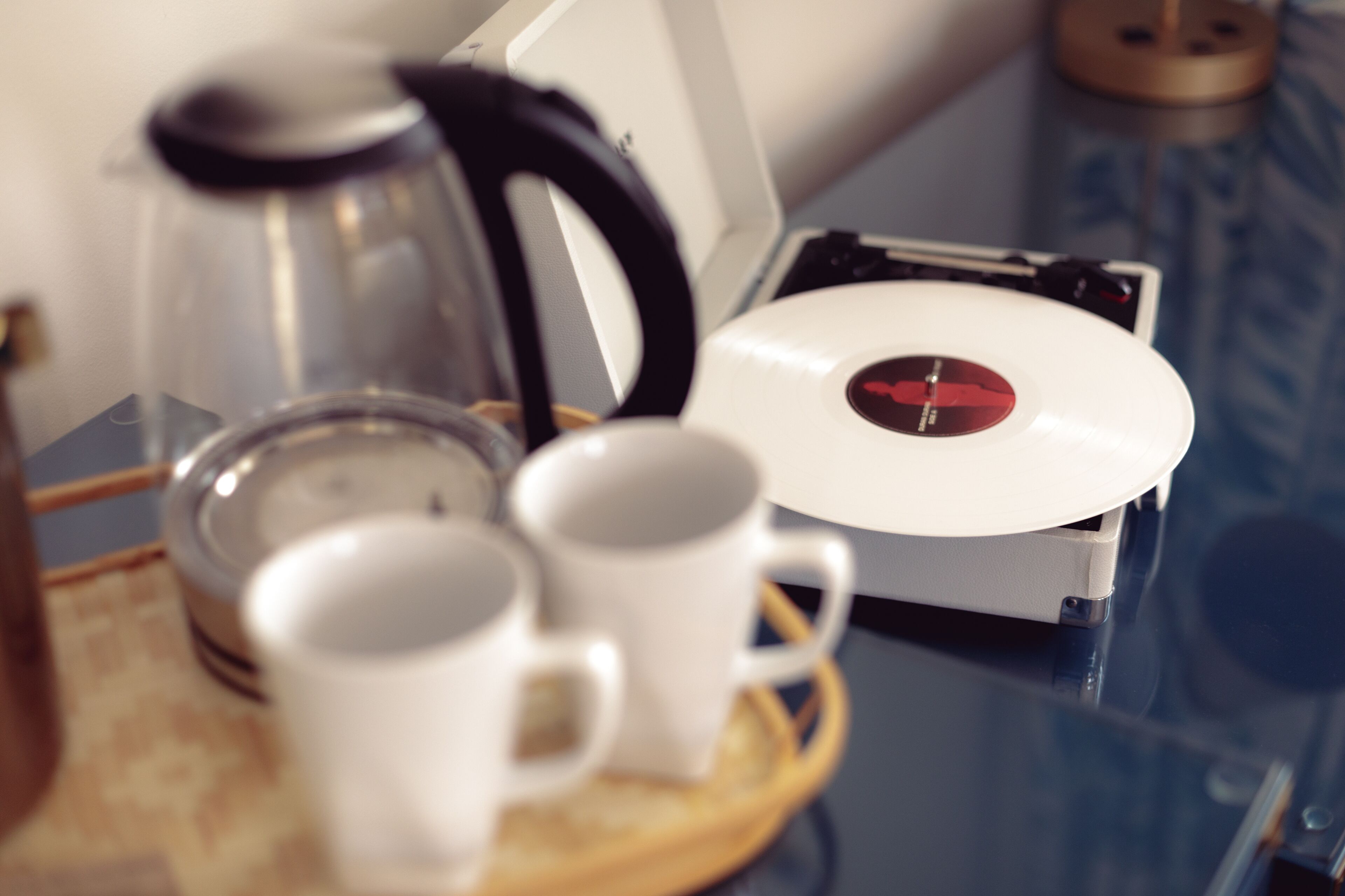 A coffee maker, a kettle, and a turntable on a tray.