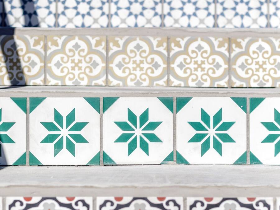 Uma fileira de azulejos decorativos com padrões geométricos e florais.