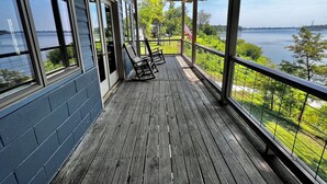 Une terrasse en bois offrant une vue sur un lac et des arbres.