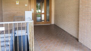 A corridor with a tiled floor, a door with a glass panel, and a metal railing. - SE014 - Senigallia, new comfortable two-room apartment in the center and on the (Senigallia)