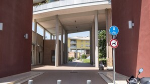 A building entrance with a covered walkway, a blue pedestrian sign, and a no dog sign. - SE014 - Senigallia, new comfortable two-room apartment in the center and on the (Senigallia)