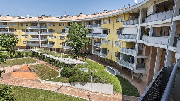 A multi-story residential building with balconies, a central courtyard with a small pool, and a surrounding grassy area. - SE014 - Senigallia, new comfortable two-room apartment in the center and on the (Senigallia)