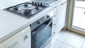 Eine Küche mit Herd, Spüle, Backofen und Waschmaschine.