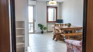 Ein Essbereich mit Holztisch und -stühlen, einer Topfpflanze und einem Fenster mit Blick.