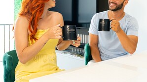 Two people sitting at a table with coffee mugs, in a room with a green wall and a modern design. - Trocean View, Luxury Apartment with Amazing Ocean View (RIO GRANDE)