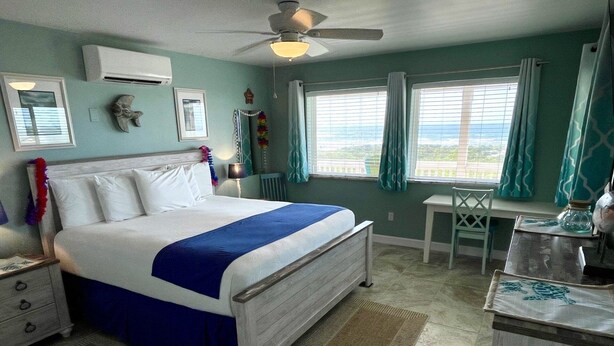 A bedroom with a bed, a desk, a chair, and a ceiling fan. - Beachgate Condo Suites And Hotel 231+232+233 3 Bedroom Condo (Port Aransas)