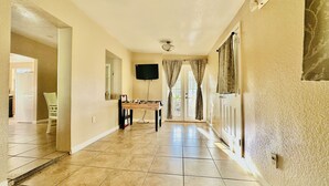 A hallway with a foosball table, a flat-screen TV, and a ceiling fan.