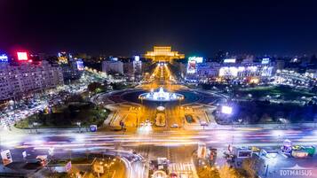 A nighttime cityscape with a roundabout and illuminated buildings.