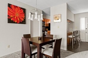 Enjoy meals in this stylish dining area with a pendant light fixture, vibrant artwork, and comfortable seating.
