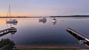 Un llac tranquil amb vaixells amarrats a un moll.