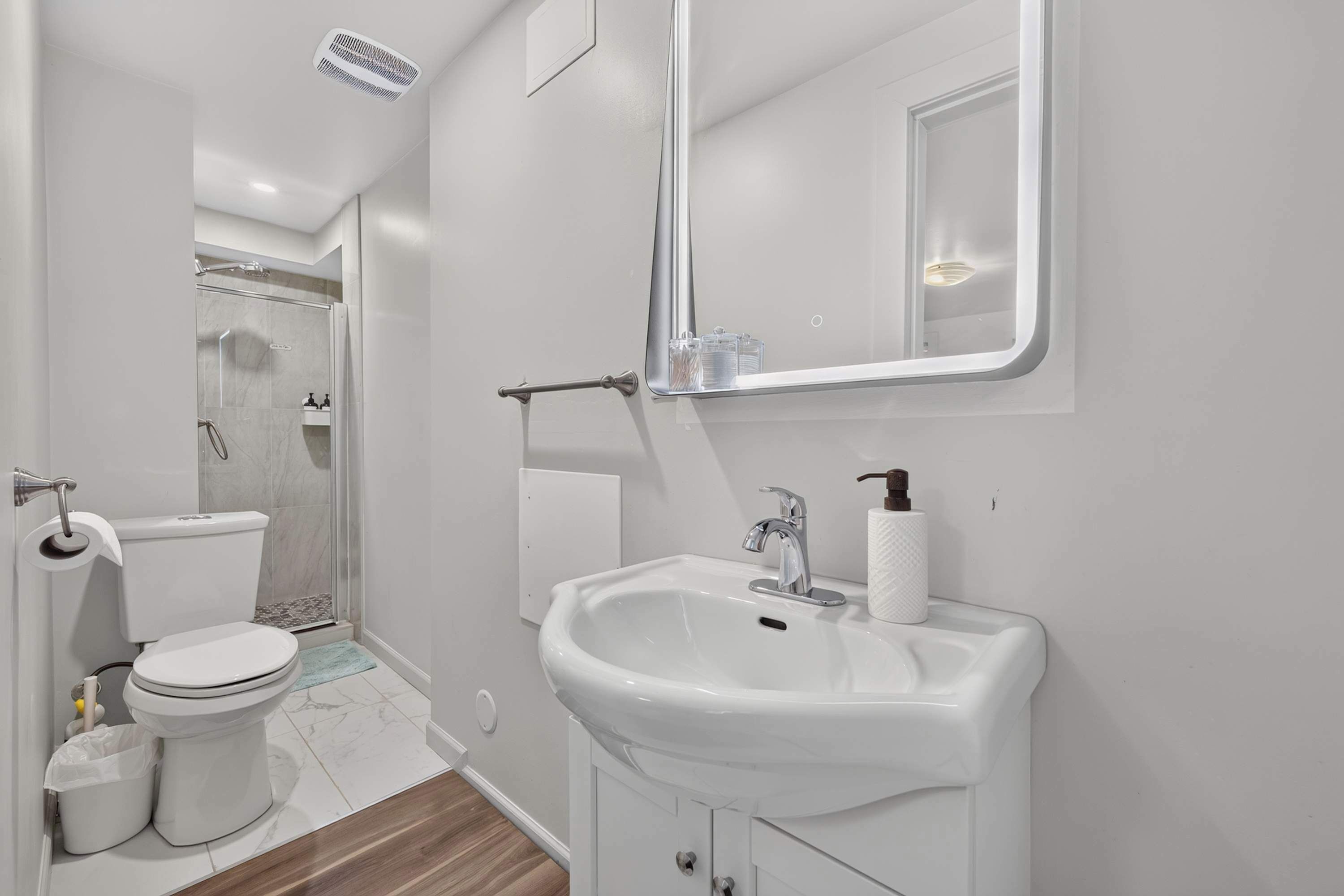 Un bagno moderno con WC, lavabo e doccia.