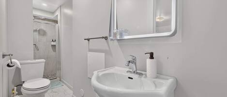 Un bagno moderno con WC, lavabo e doccia.