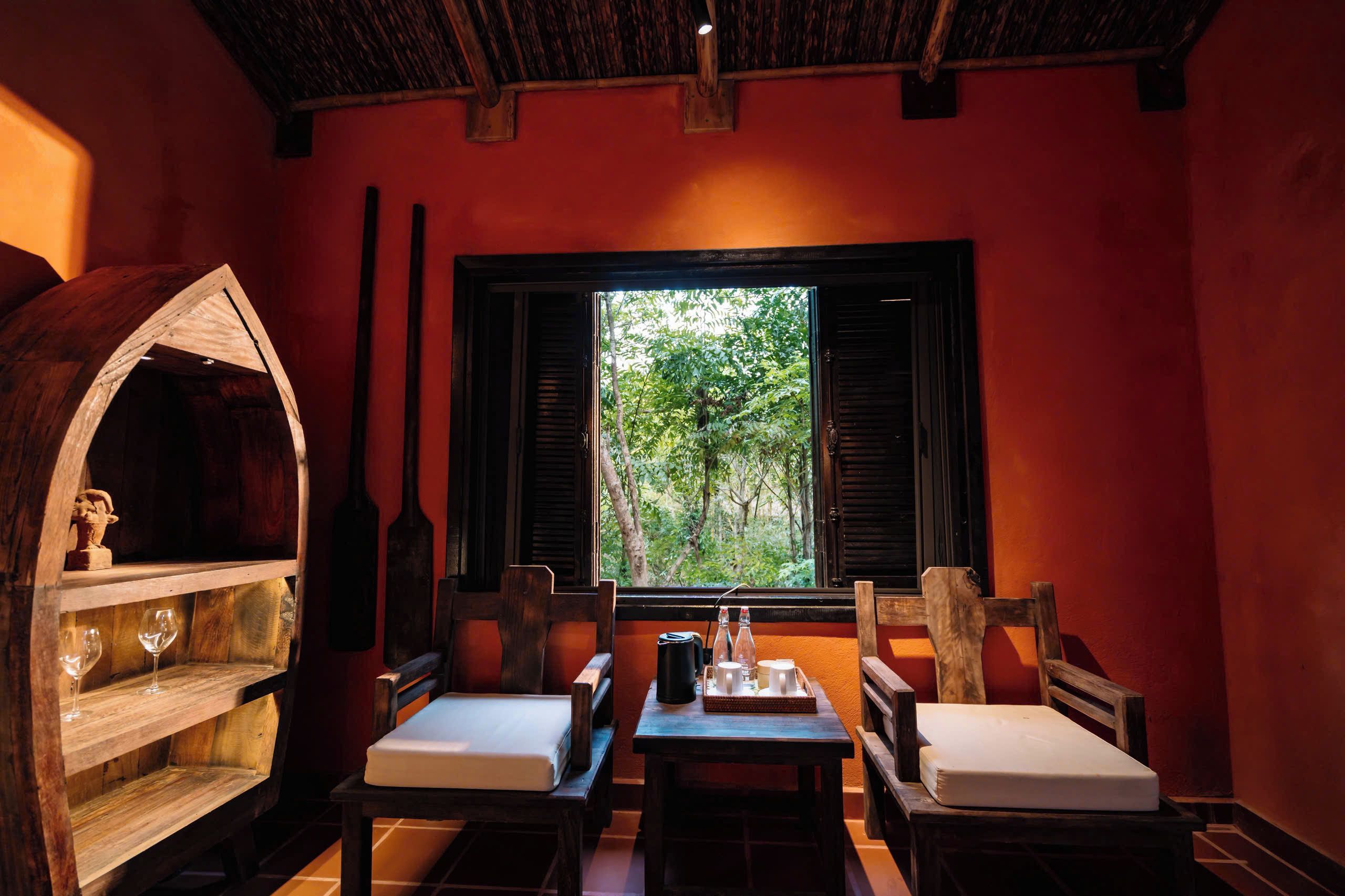 Una habitación acogedora con un barril de madera, una mesa con una bandeja y un ventanal con vistas a los árboles.