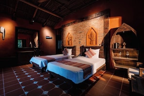 A hotel room with two beds, a brick wall, wooden decor, and a small shelf with glasses. - Whale Island Resort (Nha Trang)