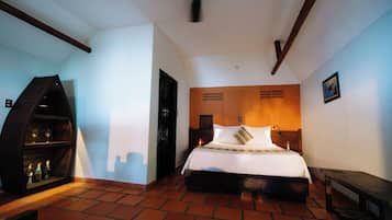 A bedroom with a bed, a wooden headboard, a nightstand, a shelf with bottles, and a ceiling fan.