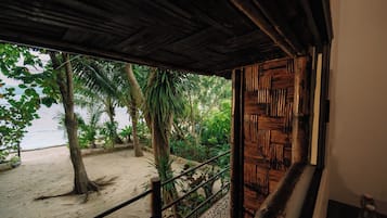 A wooden staircase leading to a beach with palm trees and a sandy shore.