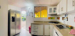 A compact kitchen with a refrigerator, sink, stove, and cabinets. - Altos de agua blanca  (Tauramena)