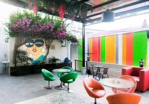 Een café met terras, een muurschildering en een kleurrijke muur.