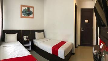 A hotel room with two beds, a nightstand, a telephone, and a painting on the wall.