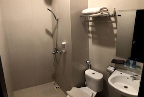 A bathroom with a shower, toilet, sink, and a towel rack. - Hotel Sg17 Tuban (Tuban)