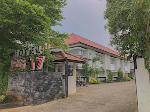 A hotel entrance with a stone wall and a sign. - Hotel Sg17 Tuban (Tuban)