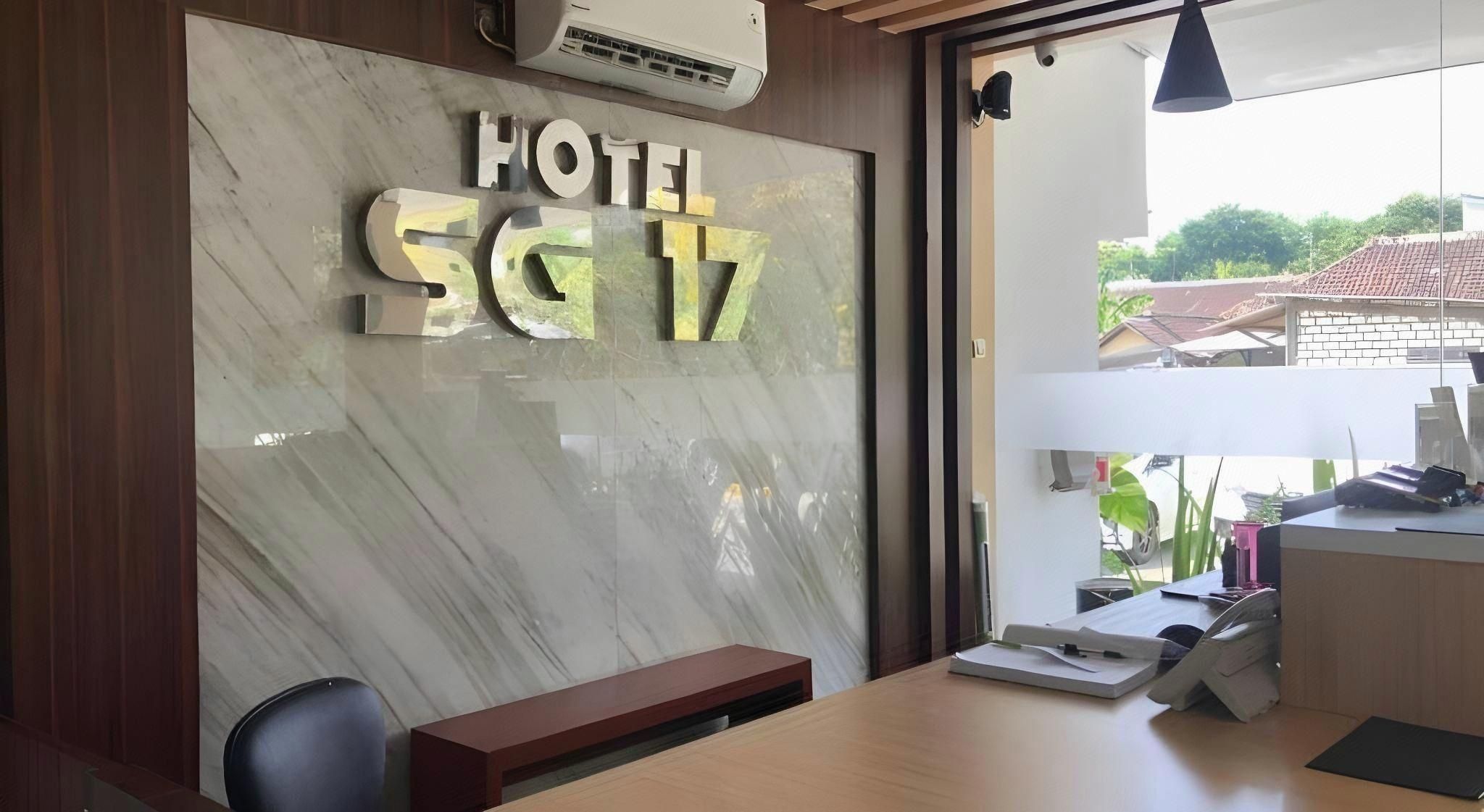 A reception desk with a marble wall and a sign reading 'HOTEL SG 17'.