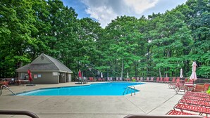 A swimming pool with lounge chairs and umbrellas, surrounded by trees. - Wintergreen Resort Vacation Rental w/ Pool Access! (Wintergreen Resort)