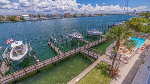 Un port de plaisance avec des bateaux amarrés, une jetée en bois et un espace piscine.
