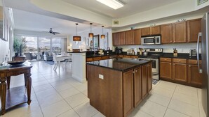 Une cuisine spacieuse avec des meubles en bois, un grand îlot central et des appareils électroménagers modernes.