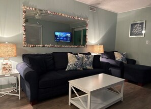 Relax in this stylish living room with a sofa, coffee table, and mounted TV.