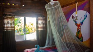 A room with a bed, a mosquito net, and a painting of a deer. - Propiedad a Orilla de Laguna (Huay-Pix)