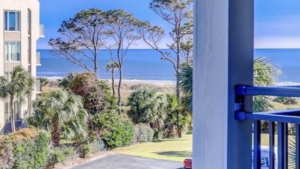 Ein modernes Gebäude mit einem Balkon mit Blick auf Strand und Meer.